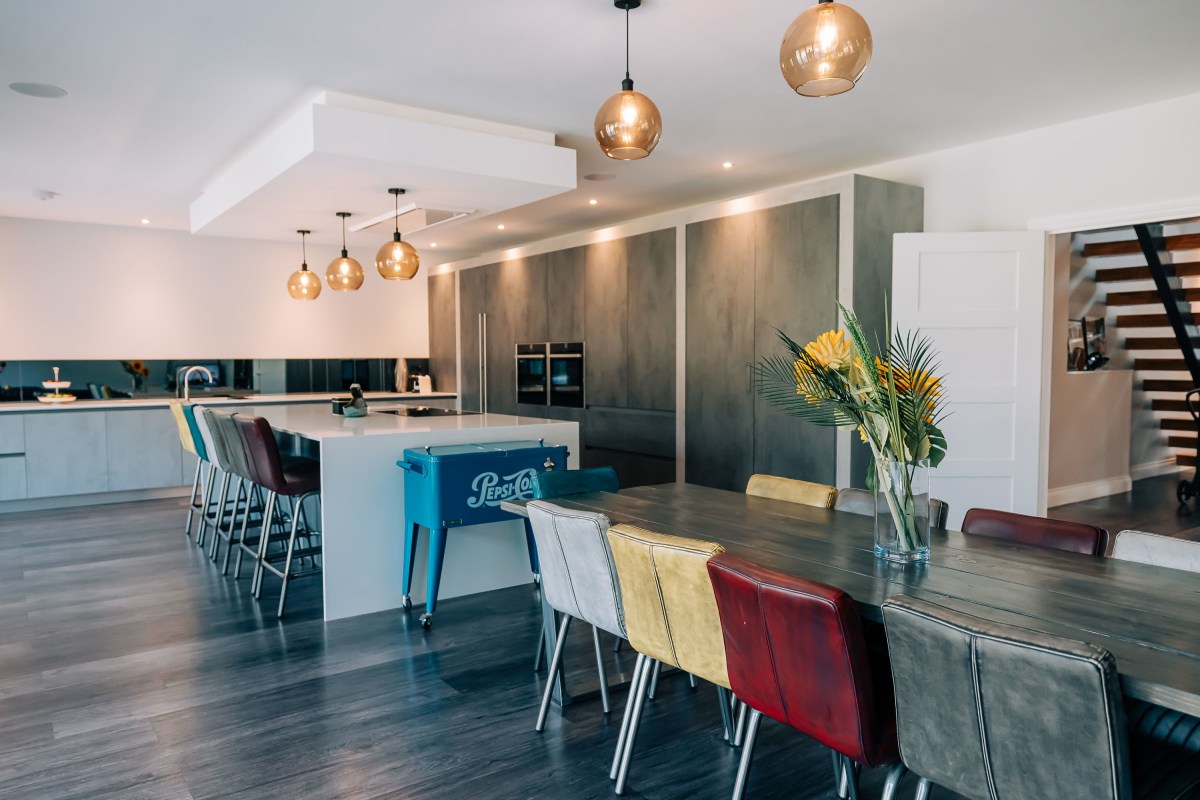 A Modern Industrial Style Kitchen with dining table, kitchen island and kitchen units in the background