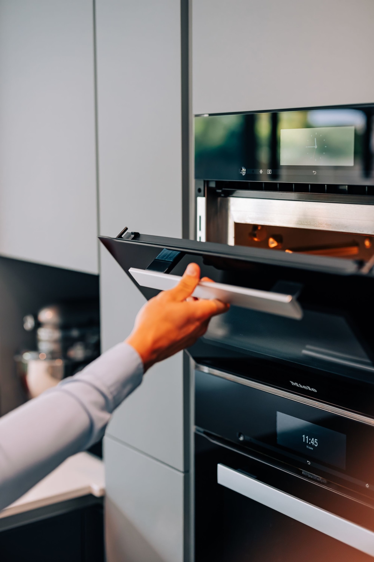 A Combination Microwave Oven being opened by a hand