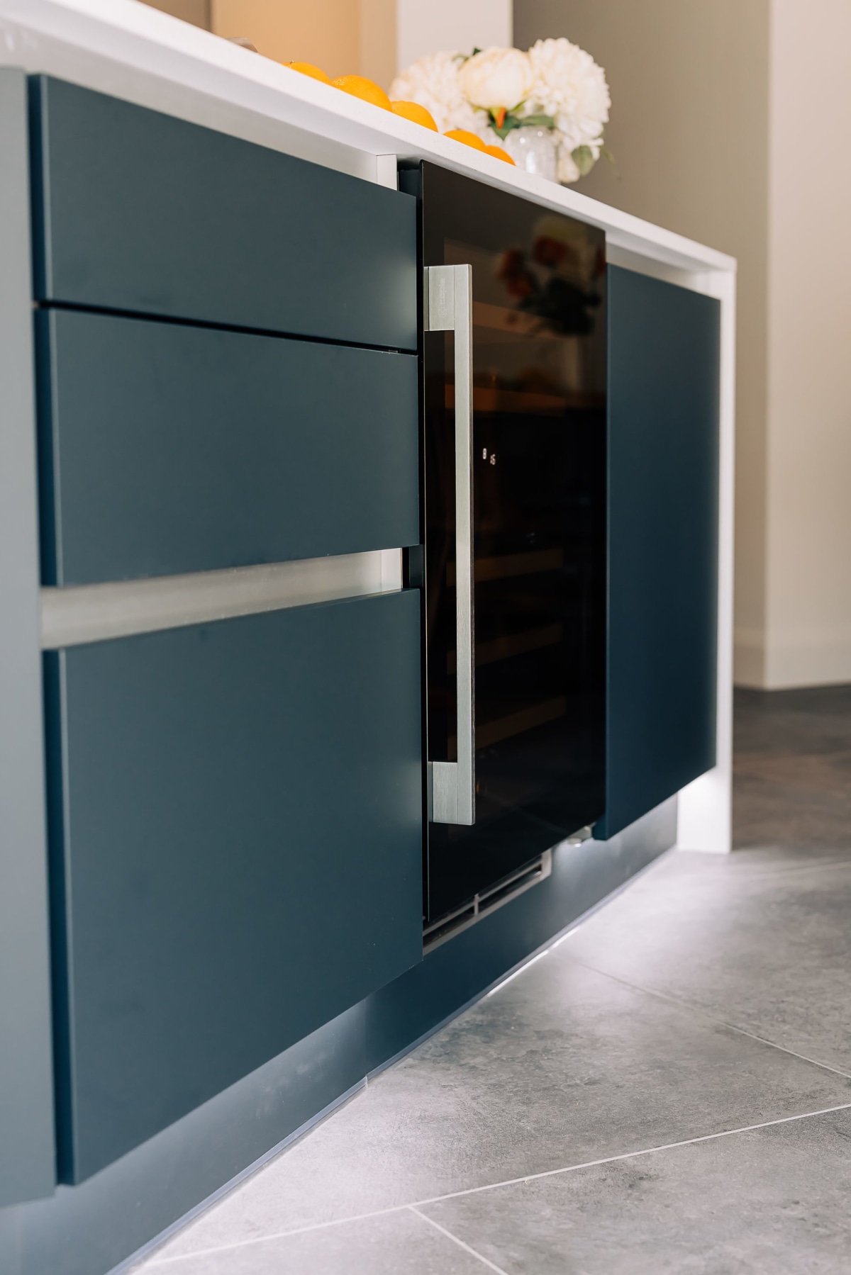 A Wine cooler with under cabinet lighting and drawers either side