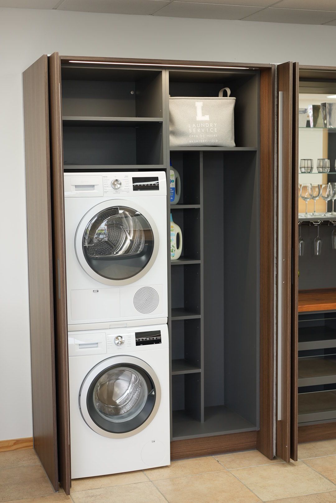 A washing machine and tumble dryer stacked on top of each other in a custom made cabinet