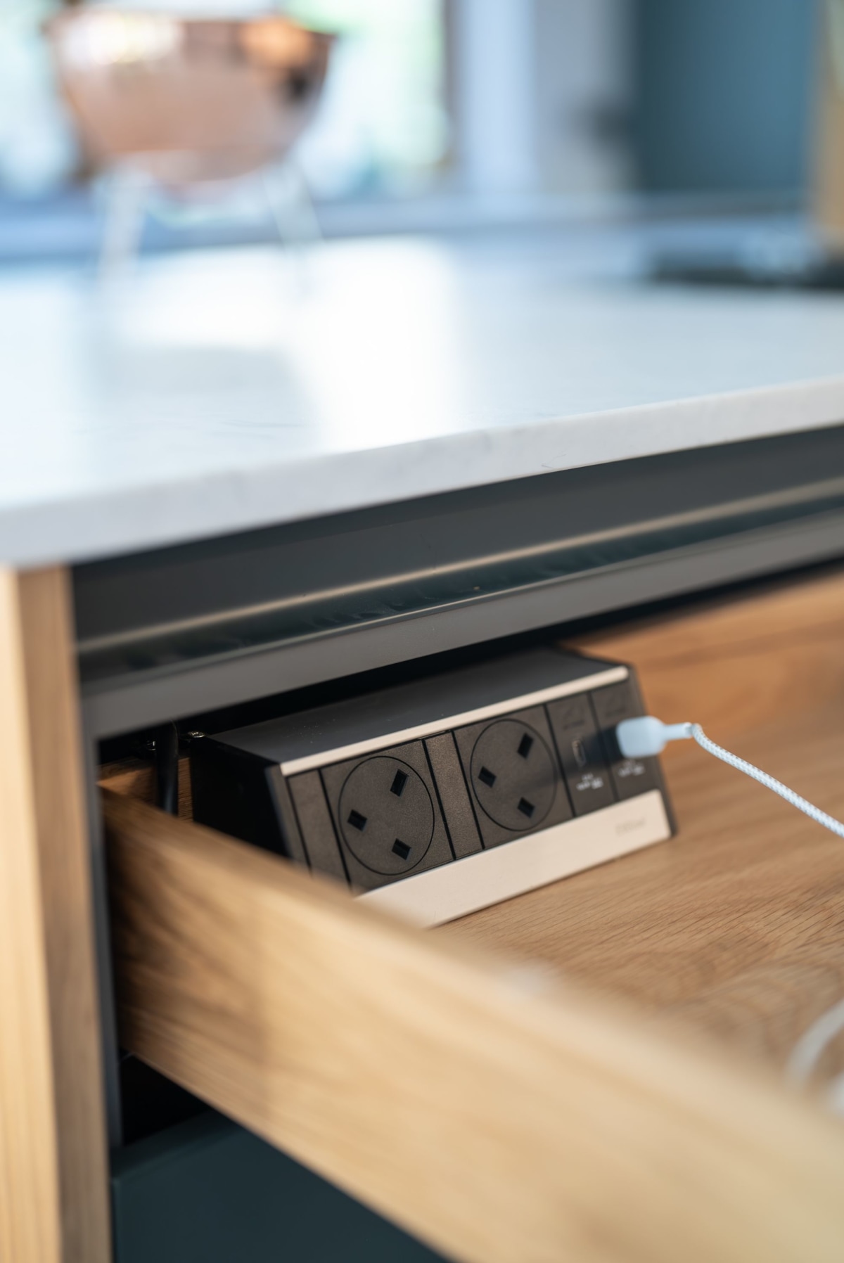 an open drawer made of oak with a hidden power source bby evoline with one cable inserted