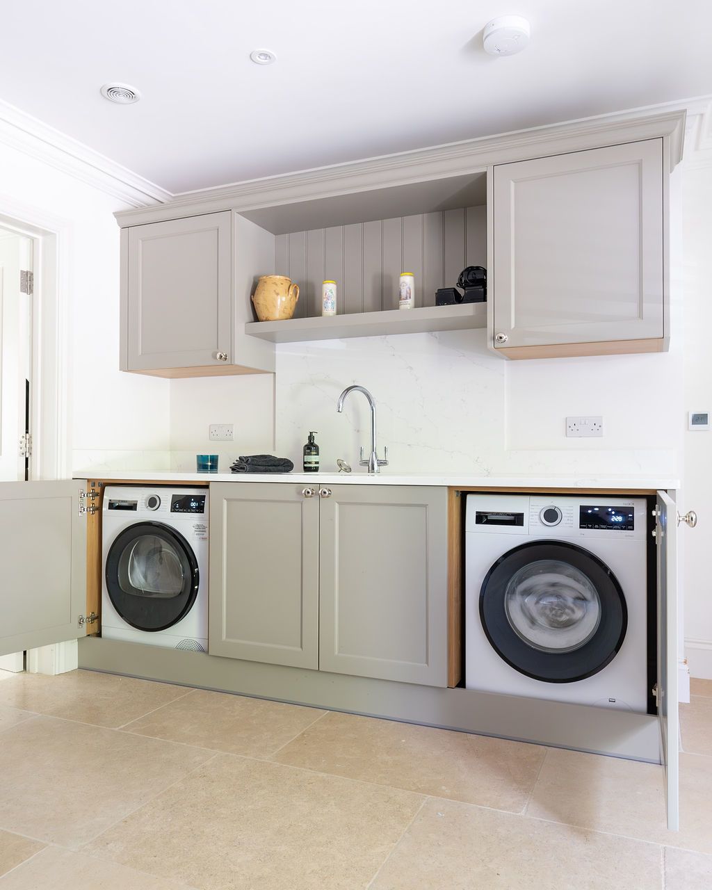 a utility room with a washer and dryer shown with doors to hide them.