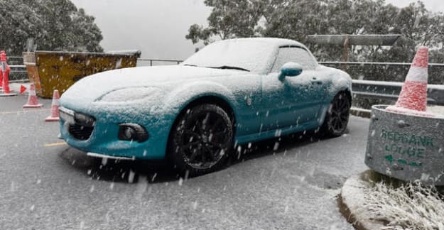 Blue Mazda in the snow