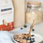 Bol pour le petit-déjeuner avec du pudding de chia, des morceaux de pomme, du granola bio et une cuillère de granola à tartiner