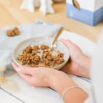 Bol de pudding de chia avec des quartiers de pommes, du granola maison et une cuillère de granola à tartiner