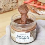 Bol de pudding de chia avec des quartiers de pommes, du granola maison et une cuillère de granola à tartiner