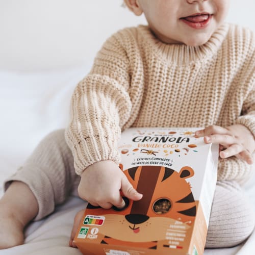 Bol pour le petit-déjeuner avec du pudding de chia, des morceaux de pomme, du granola bio et une cuillère de granola à tartiner