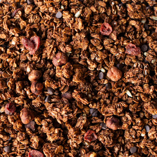 Bol de pudding de chia avec des quartiers de pommes, du granola maison et une cuillère de granola à tartiner