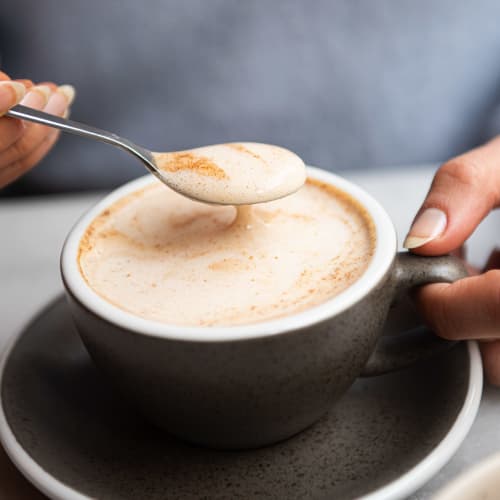 Bol pour le petit-déjeuner avec du pudding de chia, des morceaux de pomme, du granola bio et une cuillère de granola à tartiner