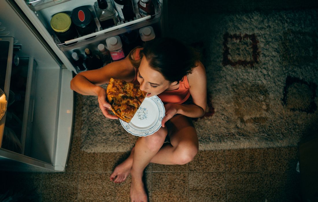 woman eating pizza at night
