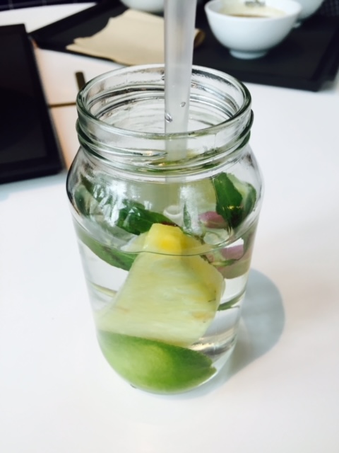 a cup of water with fruit pieces inside