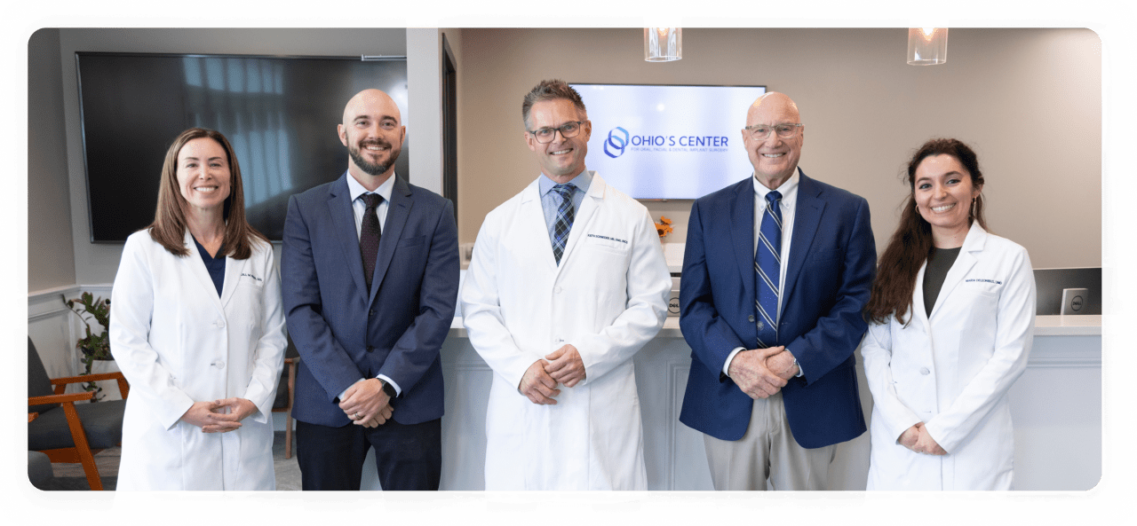 The five oral surgeons of Ohio's Center standing together in the reception area of the Mentor office