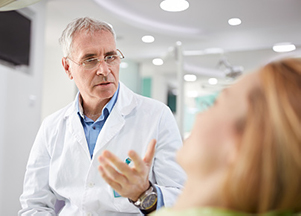 Smiling dental professional consulting a patient, at Madison Oral Surgery & Dental Implants.