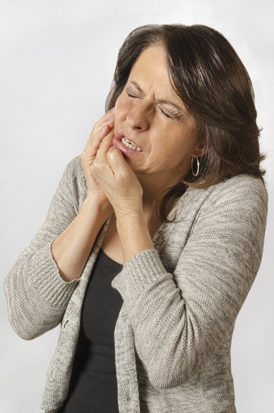 An elderly woman suffering from severe TMJ. An elderly woman suffering from severe TMJ.