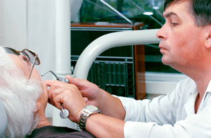 An elderly woman receiving a dental exam. An elderly woman receiving a dental exam.
