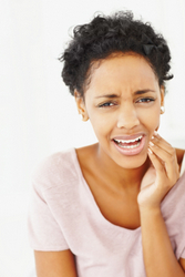 A woman suffering from swelling cheeks after an oral surgery procedure at Madison Oral Surgery & Dental Implants.