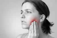 A woman in pain; after having a wisdom tooth removed. A woman in pain; after having a wisdom tooth removed.
