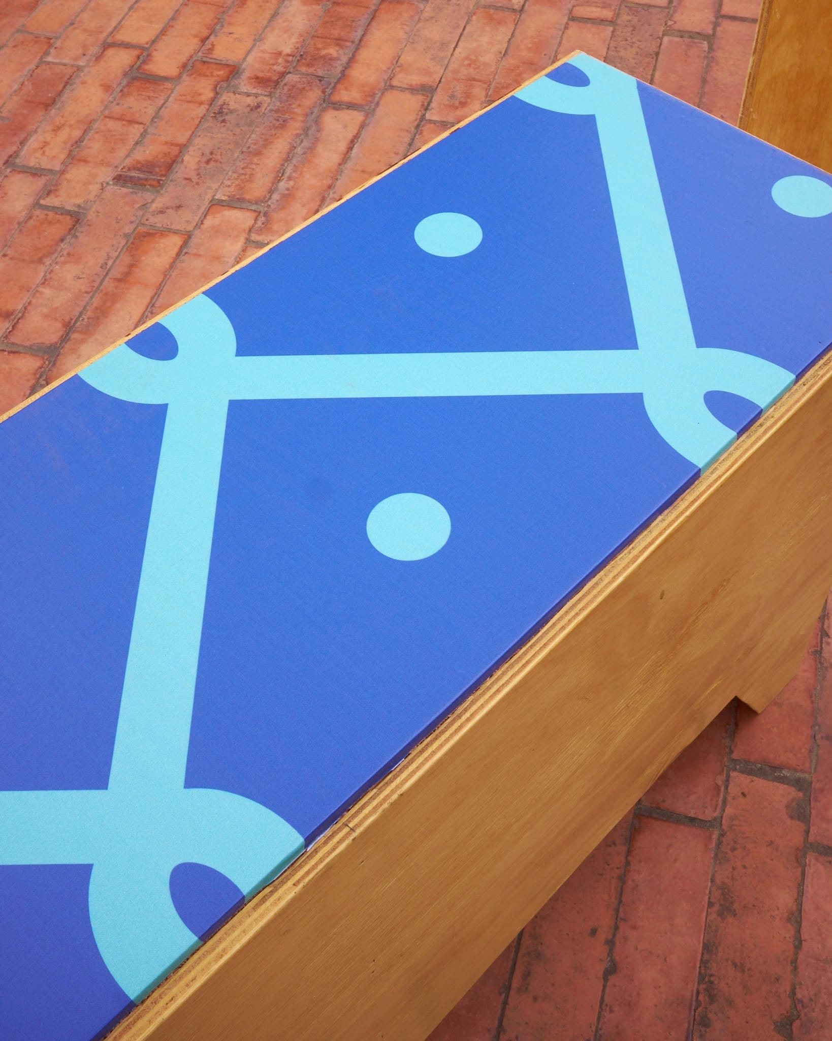 Banca de madera intervenida con patrón geométrico azul