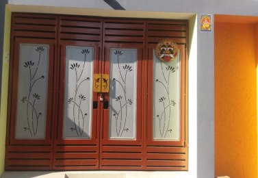 Laser-cut window grill with floral vine pattern in maroon and cream