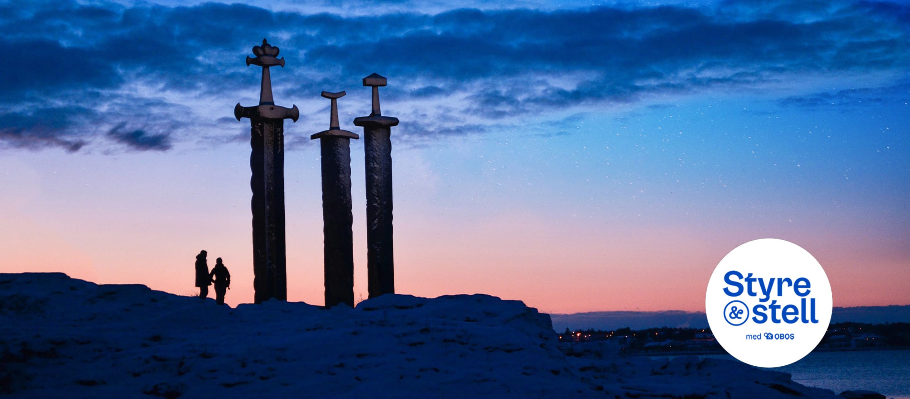 To mennesker ved sverd i fjell i solnedgang