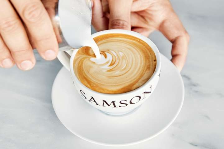 En som fyller opp en kopp kaffe