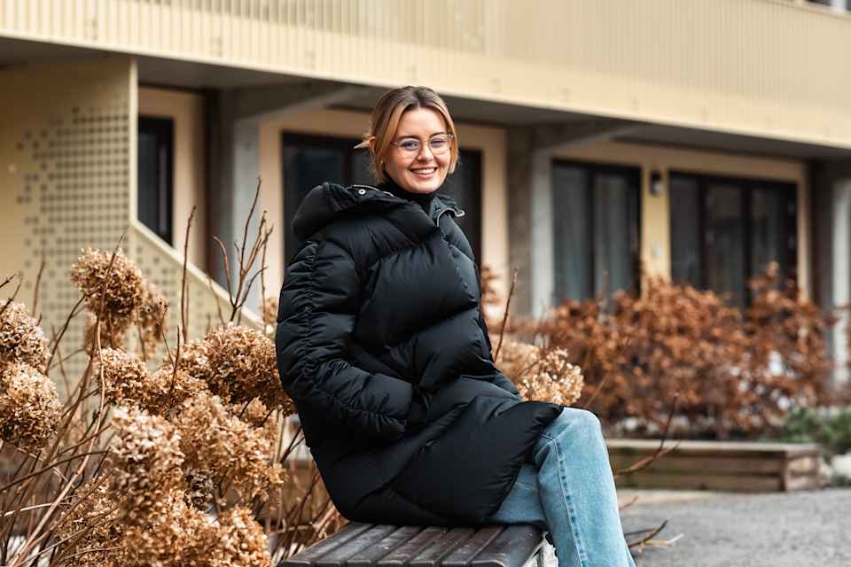 Ragnhild Helen Løvli sitter på en benk i et borettslag som har tilrettelagt eldre.