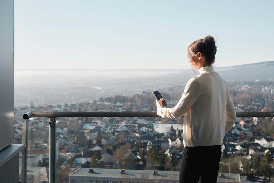 Styreleder i Grefsentoppen boligsameie, Ingunn Roald, står på balkongen sin.