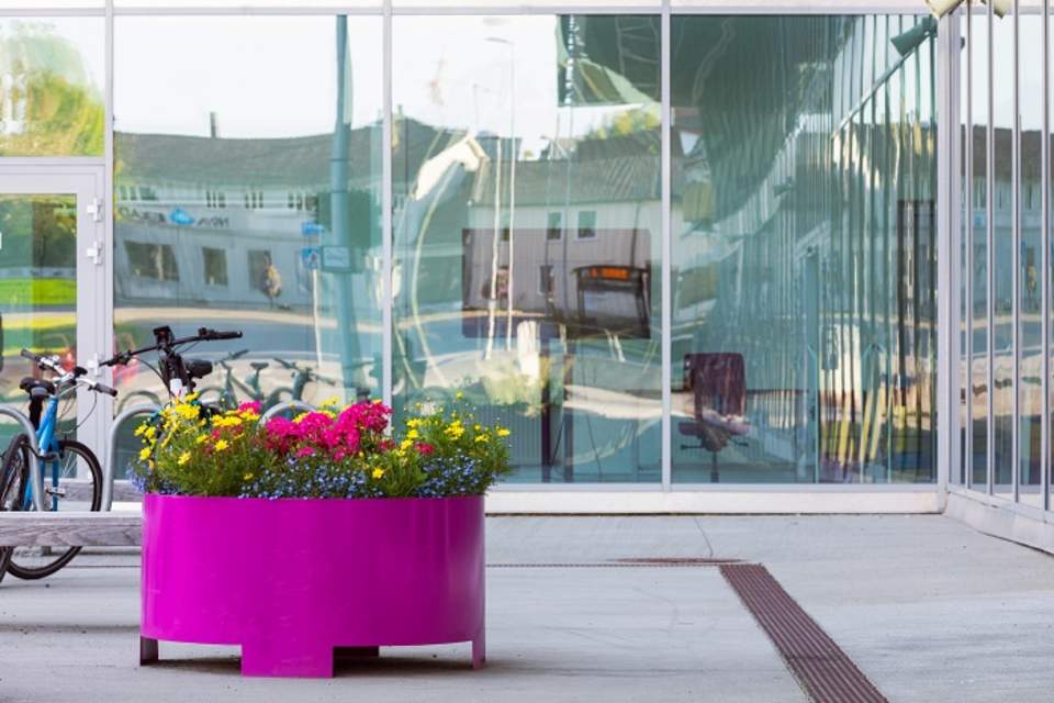 En lilla plantekasse utenfor en bygning.