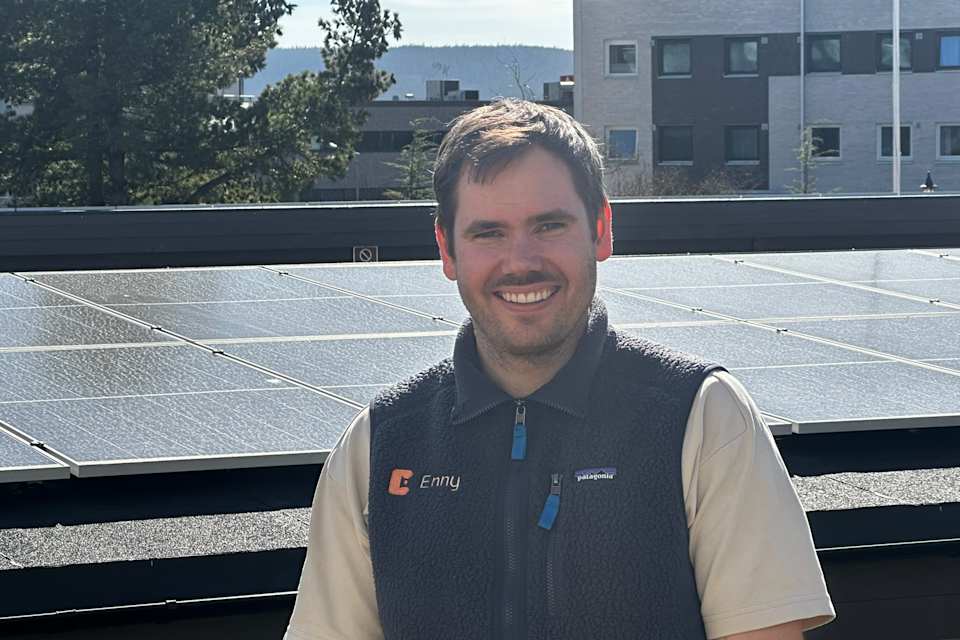 Ansatt i Enny står foran et tak med solceller