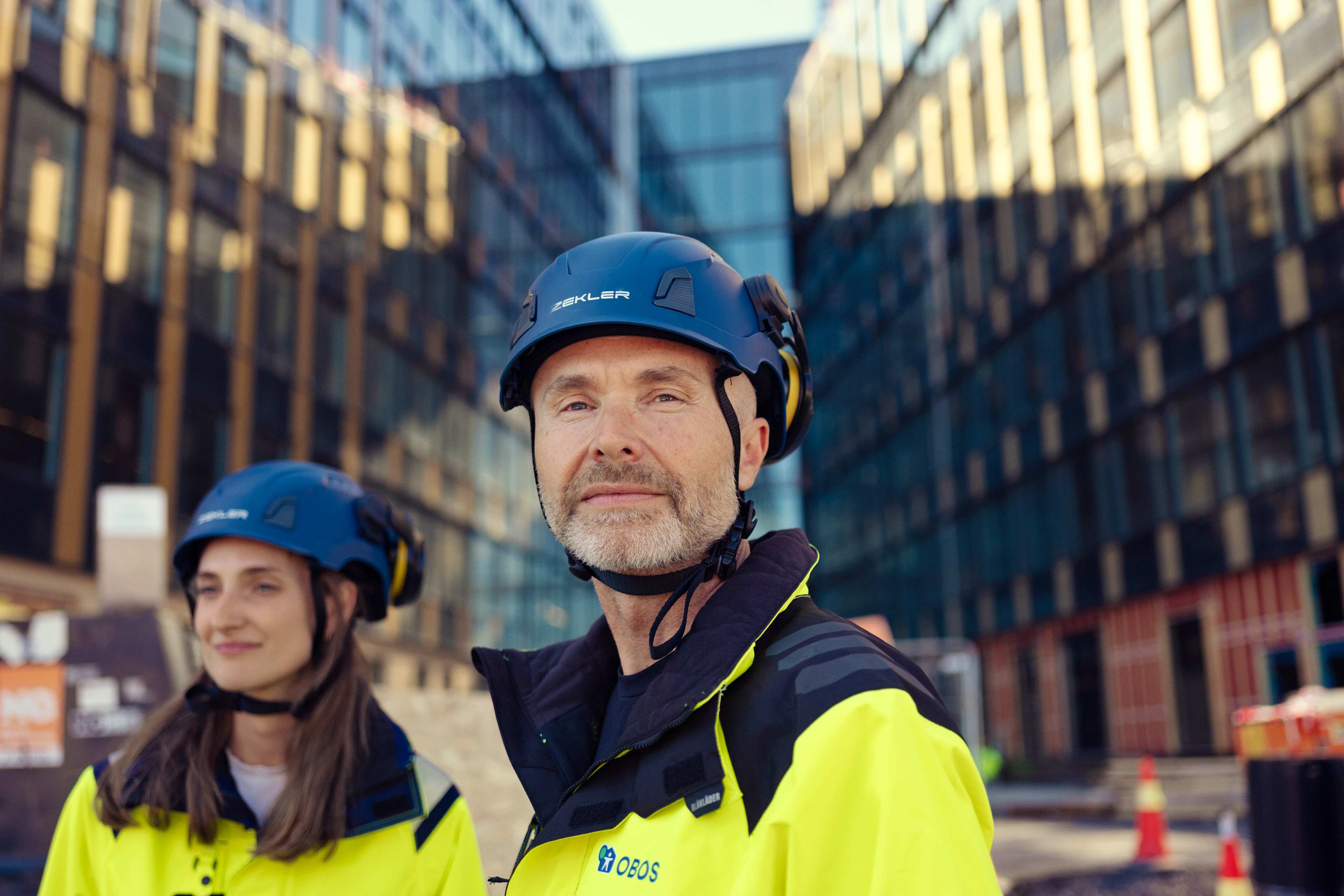 Mann og kvinne i arbeidsklær på en byggeplass