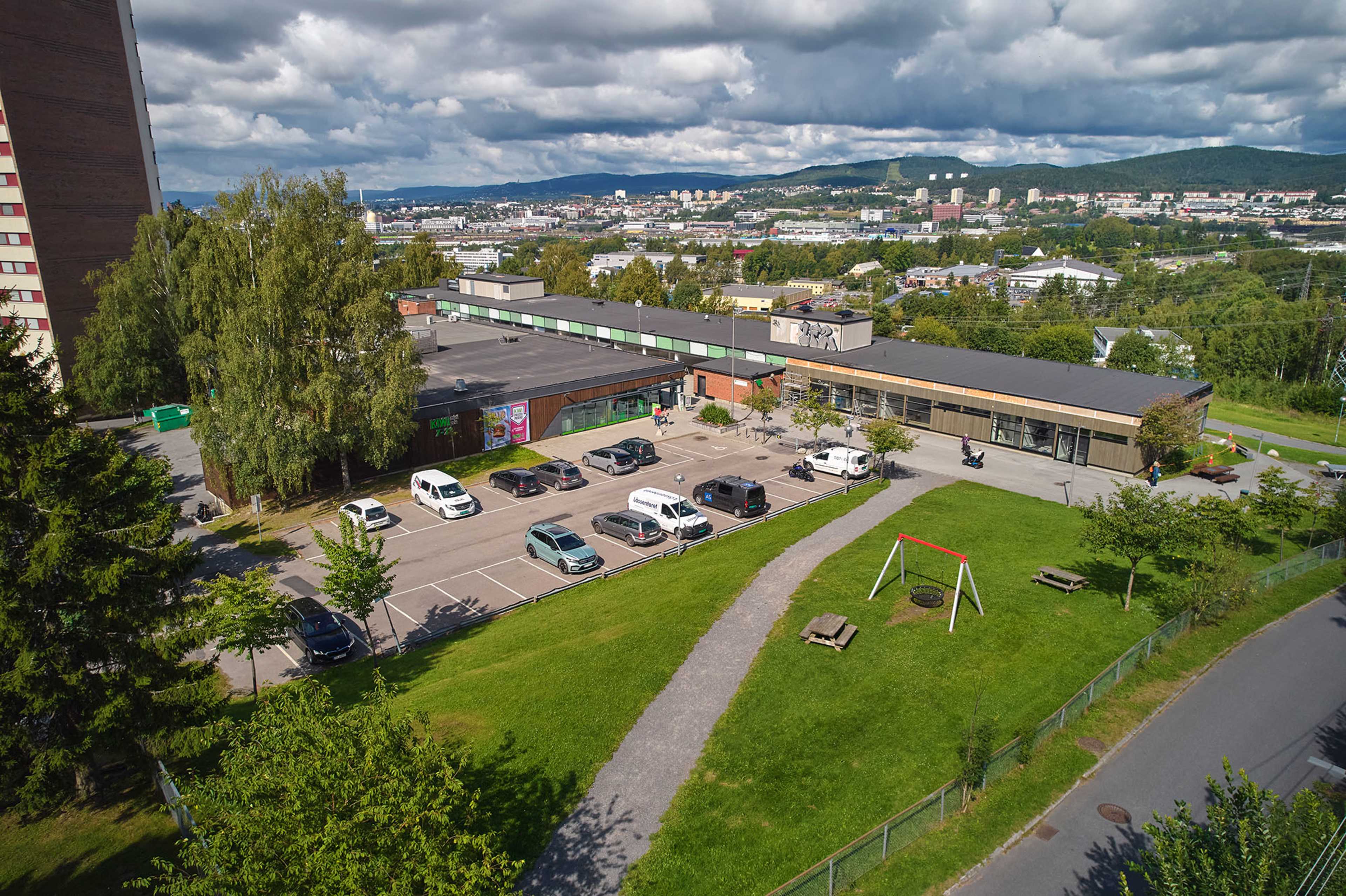 Dronefoto av hele Trosterud Torg med tilhørende parkeringsplass.