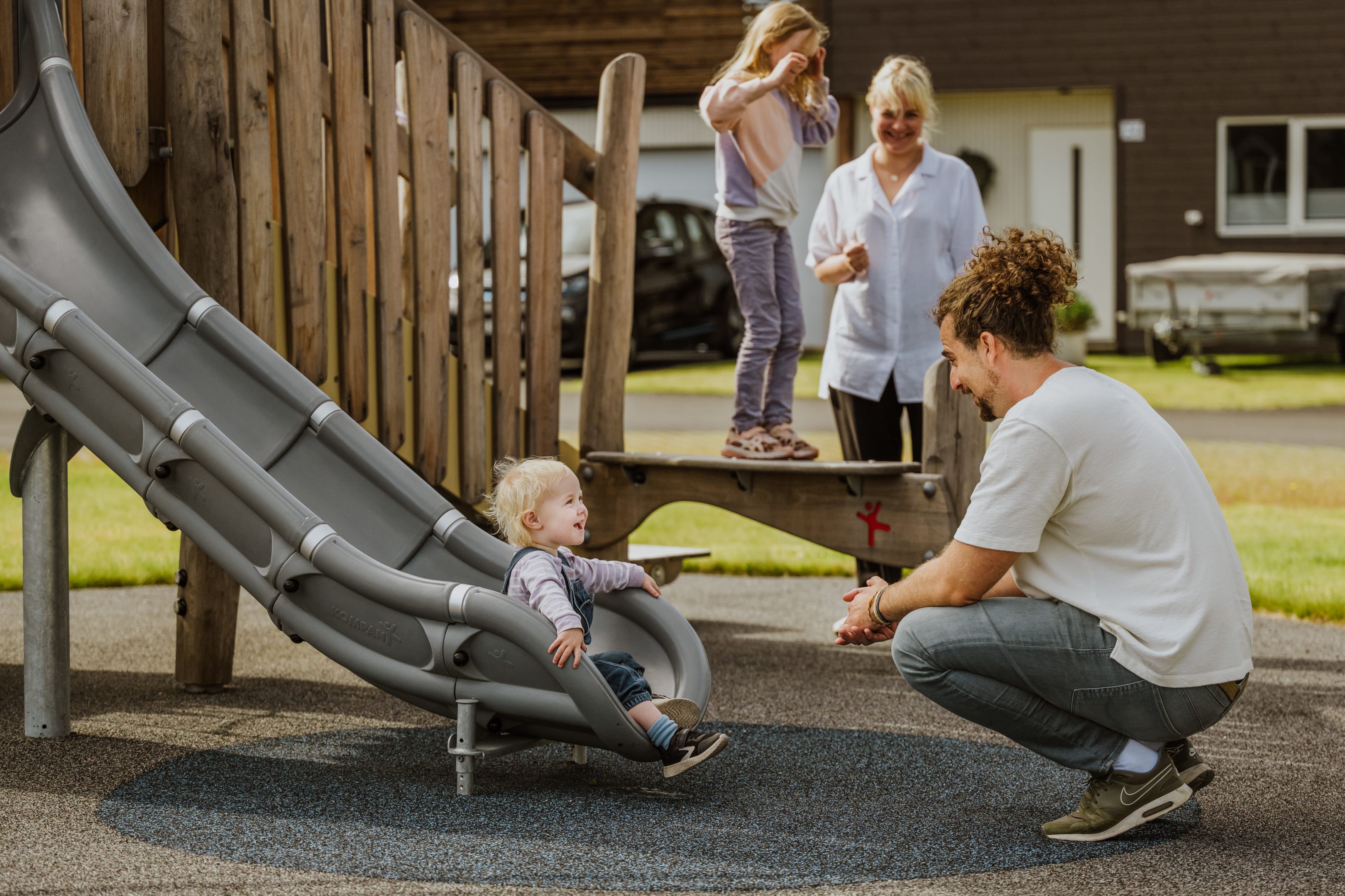 Familie leker sammen på en lekeplass i et OBOS Block Watne-nabolag