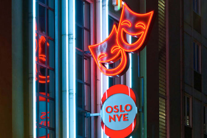 Skiltet til Oslo Nye Teater og teatermasker i neon