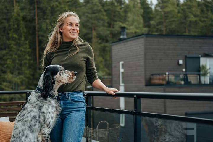 Kvinne med hund på terrasse i OBOS Block Watne-bolig