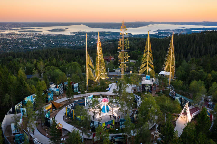 Utsiktsbilde over Roseslottet fra Holmenkollen. Det er solnedgang.