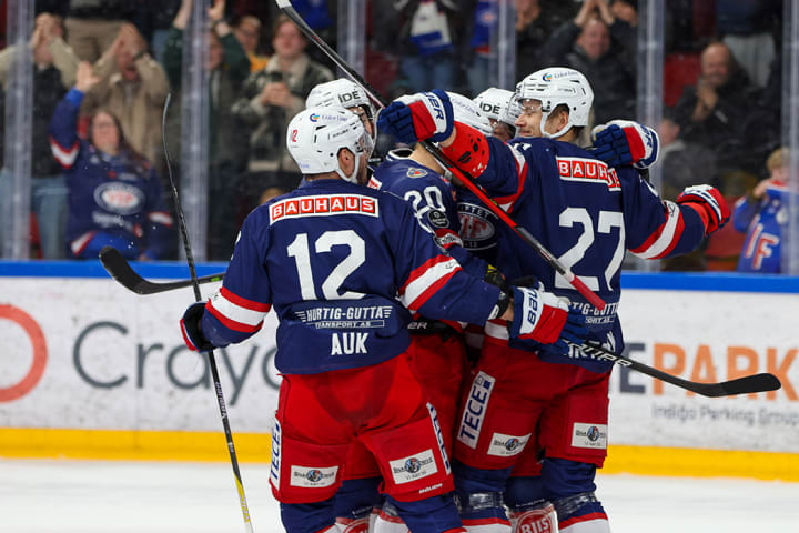 Foto av spillere fra Vålerenga Hockey som står på isen og feirer et mål.