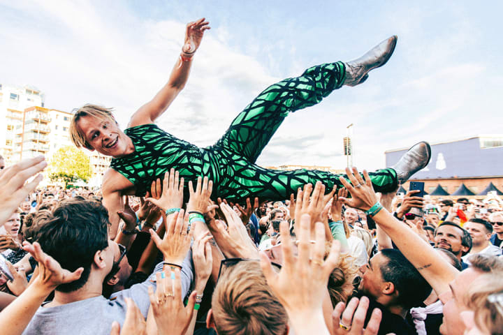 Foto av artisten Sondre Justad som crowd-surfer på en konsert.