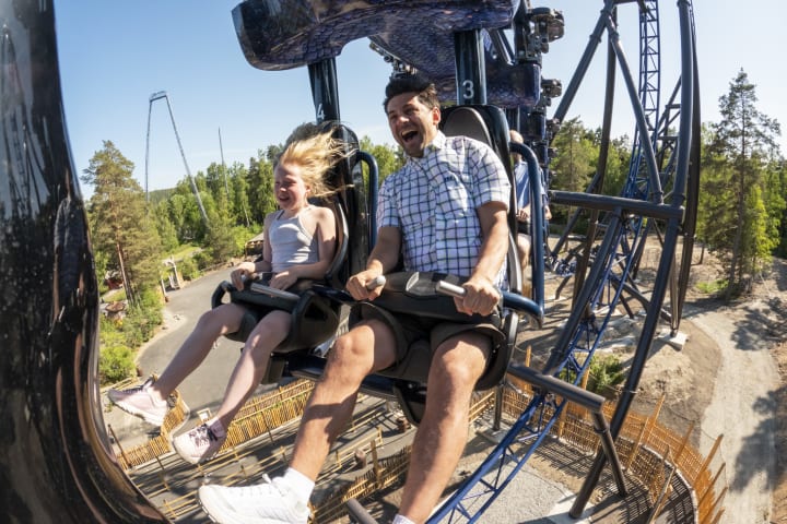 Flere barn kjører karusell på Tusenfryd. Et barn smiler fra øre til øre mens han sitter på en motorsykkel.