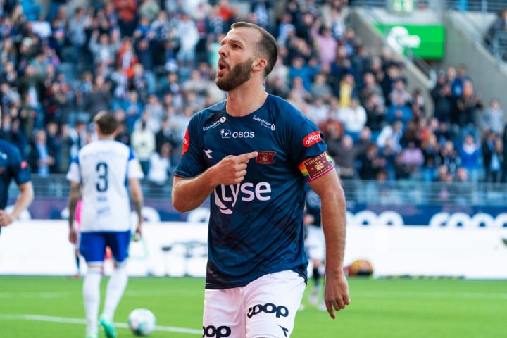 Tre fotballspillere fra Viking som klemmer og feirer sammen på den grønne fotballbanen