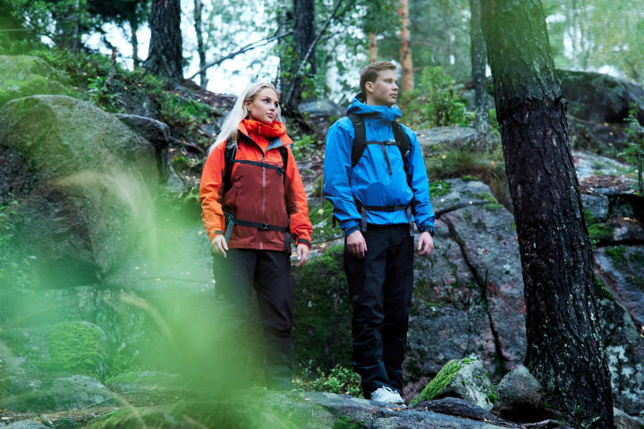 Tre gutter står ved hver sin kule sykkel i rødt og grønt. De har på seg hjelm. Det er varmt i været.