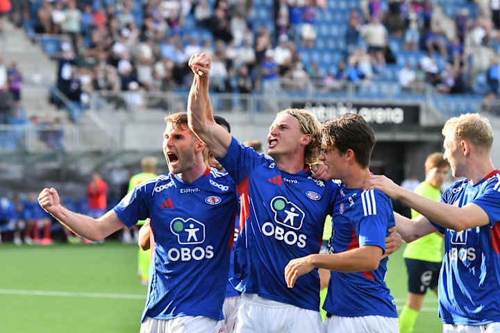Foto av fire Vålerenga fotballspillere som feirer på fotballbanen.