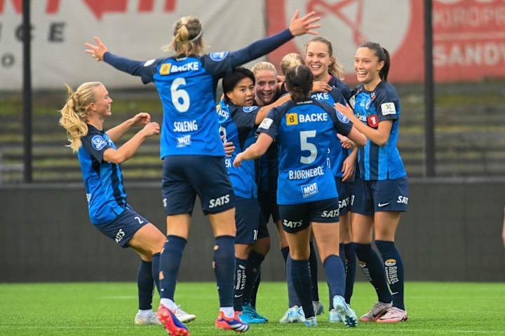 Foto av flere Stabæk Fotball Kvinner som klemmer og feirer under en fotballkamp.