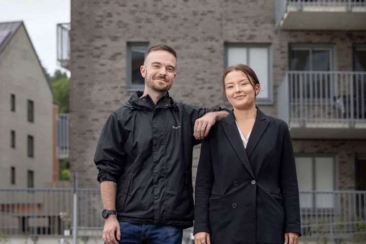 Syskonpar leende utanför lägenhetshus