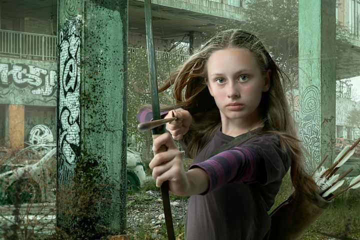 Skuespilleren som er Robin Hood i stykket ser i kamera og sikter med pil og bue.