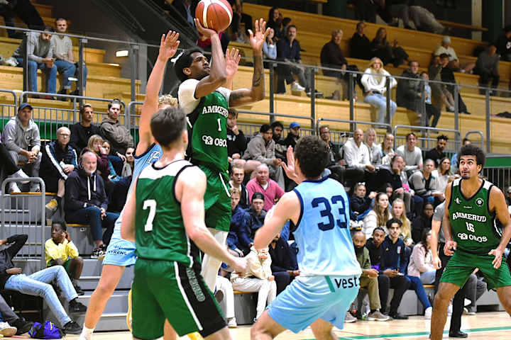En av spillerne til Ammerud Basket tar sats og kaster ballen mot mål.