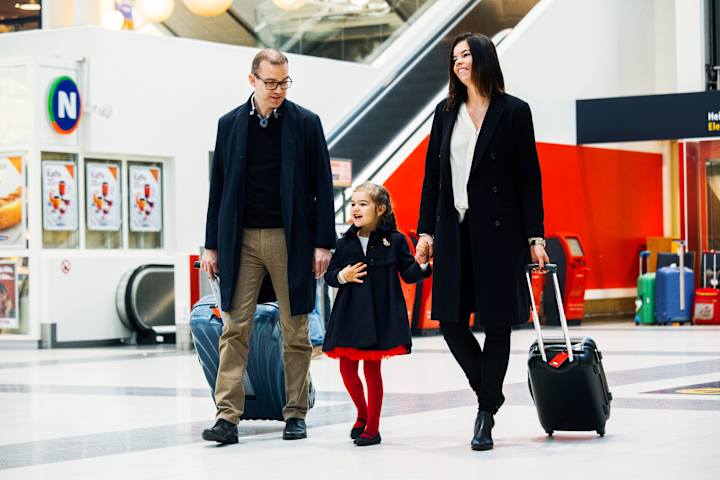 En familie er på flyplassen og skal reise et ted. De er pent kledd.