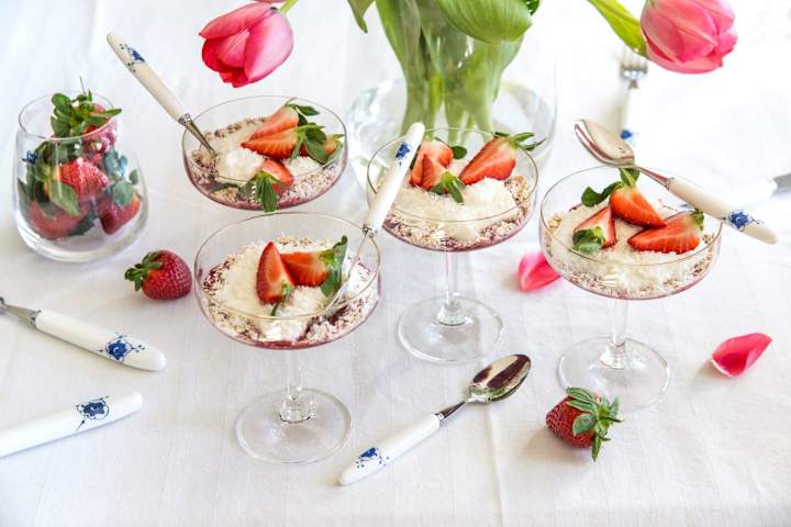 Et pyntet bord med dessertskåler med is og jordbær.