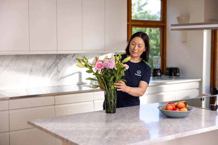 Kvinna som sätter blommor i en vas