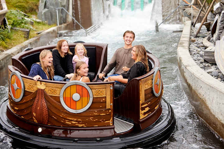 Flere barn kjører karusell på Tusenfryd. Et barn smiler fra øre til øre mens han sitter på en motorsykkel.