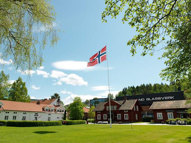 Et par beskuer lampene hos Hadeland Glassverk. De smiler. De har også jakkene på.